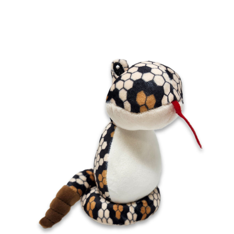 Angle view of a plush diamondback snake toy with a predominantly white body and black and brown patterned head and tail.