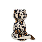 Back view of a plush diamondback snake toy with a predominantly white body and black and brown patterned head and tail.