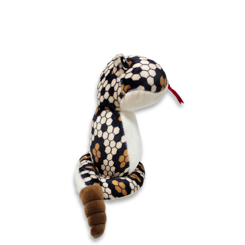Side view of a plush diamondback snake toy with a predominantly white body and black and brown patterned head and tail.