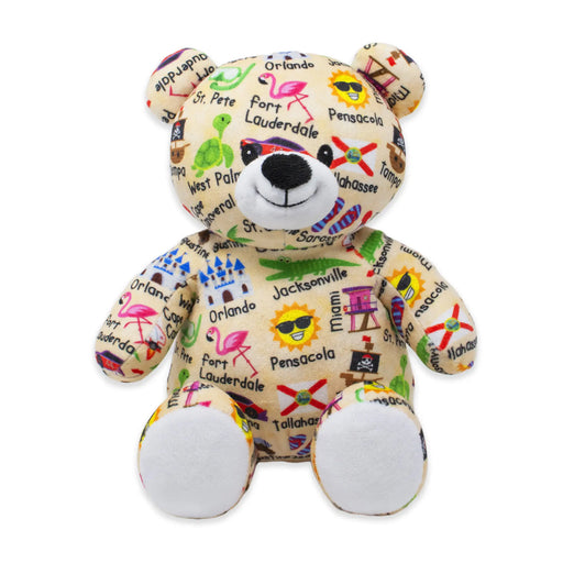 Plush bear with colorful designs and text on a white background.