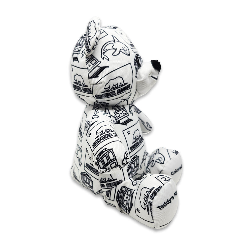 Side view of a white teddy bear plush covered in black California Republic illustrations, with text on the feet reading “Teddy’s Name” and “Colored On.”