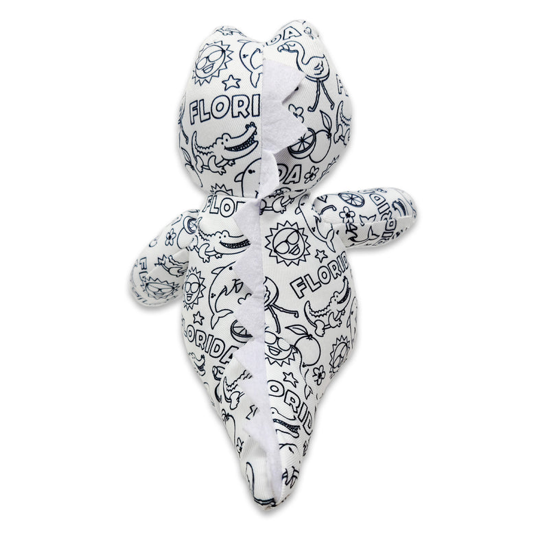 Back angled view of a black-and-white colorable plush frog printed with Florida-themed outlines, showing the stitched center back seam.
