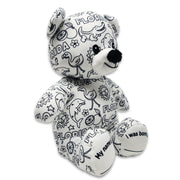 Front angled view of a white teddy bear plush covered in black Florida-themed illustrations, including alligators, flamingos, dolphins, oranges, suns, and the word Florida.