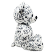 Side view of a white teddy bear plush covered in black Florida-themed illustrations, including alligators, dolphins, flamingos, suns, oranges, and the word Florida.