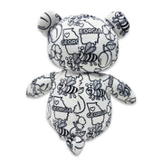 Back view of a black and white Georgia-themed teddy bear plush with bees, flowers, peaches, and “Georgia” text printed across the fabric, featuring “My name is” and “I was born on” text on the feet, on a white background.