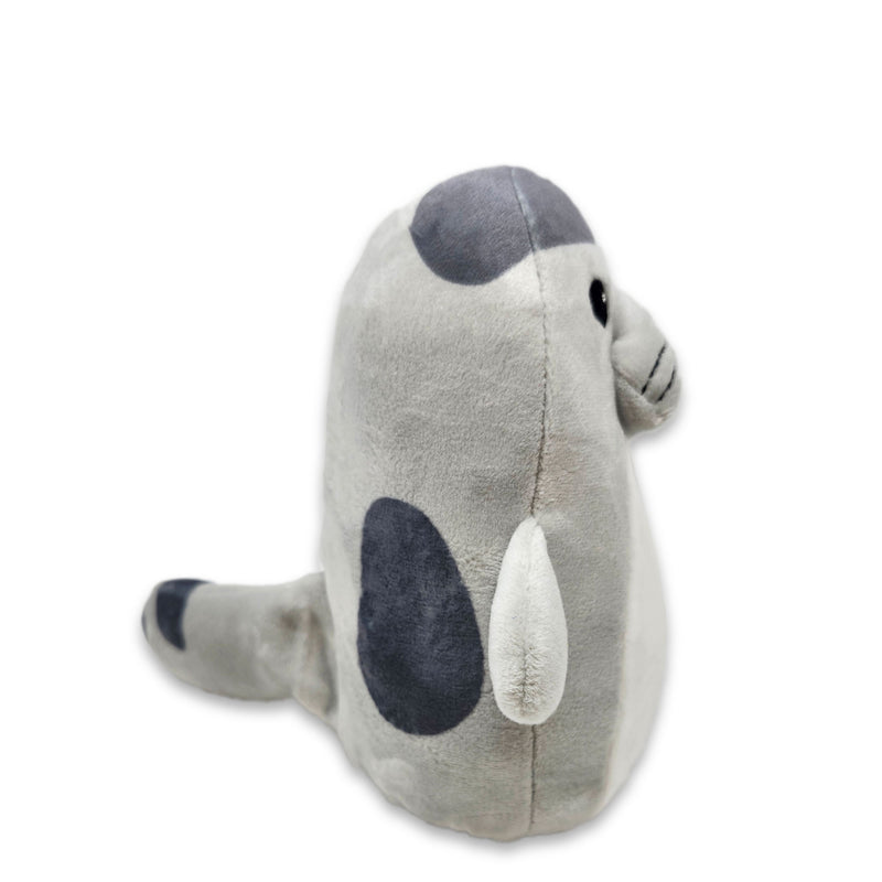 Side view of a gray and white plush seal with stitched facial features and small side flippers, on a white background.