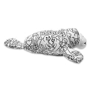 Side view of a black and white color-me plush manatee with printed cartoon designs and text, lying flat on a white background.
