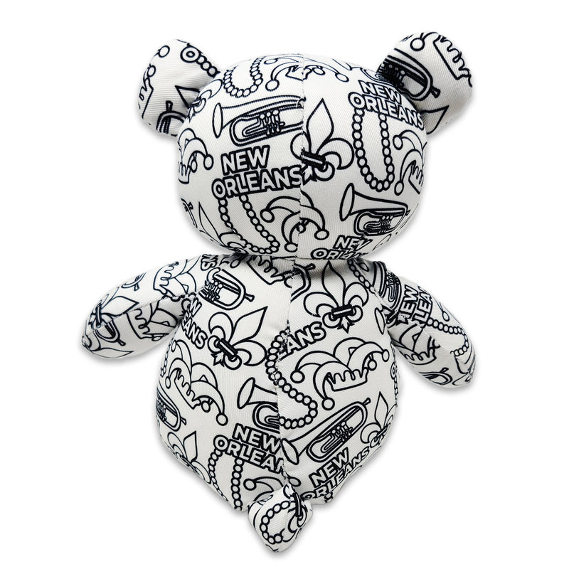Back view of a black-and-white colorable plush bear covered in New Orleans text, fleur-de-lis symbols, trumpets, beads, and city-themed designs.