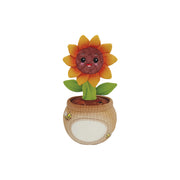 Plush sunflower toy with a face in a woven pot on a white background