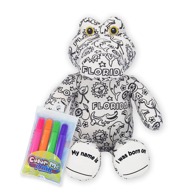 Front view of a black-and-white colorable plush frog covered in Florida-themed outlines and text, shown with a pack of four washable markers and foot text that reads “My name is” and “I was born on.”