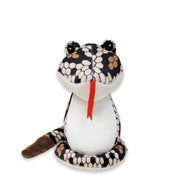 A plush diamondback snake toy with a predominantly white body and black and brown patterned head and tail.