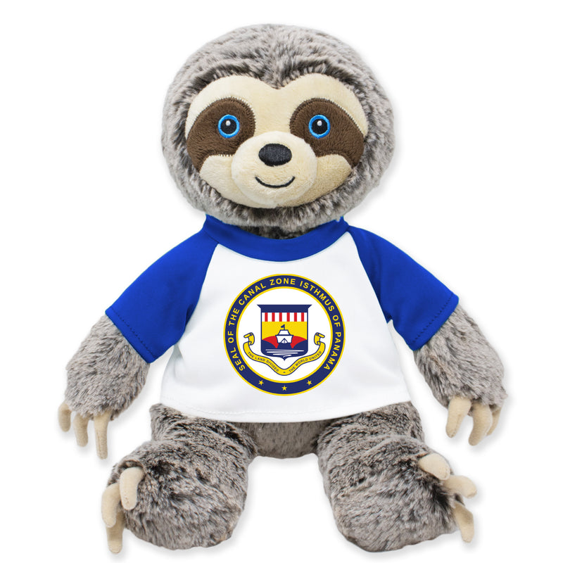 A plush toy depicting a sloth with a blue shirt and a Panama Canal Zone emblem on its chest.