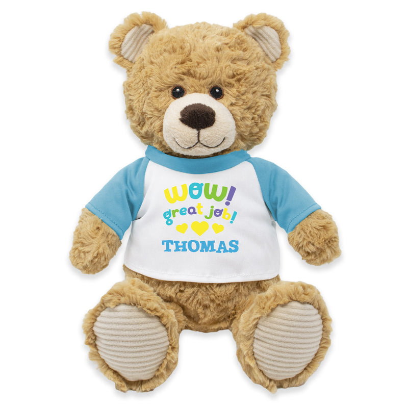 A plush teddy bear wearing a white shirt with a blue and yellow bow tie, and the text 'WOW! GREAT JOB, THOMAS!' printed on it.