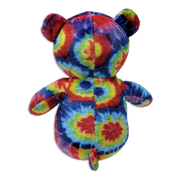 Back view of a tie-dye plush teddy bear with multicolored rainbow fabric, rounded ears, short arms, small tail, and visible center seam on a transparent background.