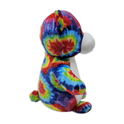 Side view of a tie-dye plush teddy bear with multicolored rainbow fabric, white snout and belly, rounded ears, and seated posture on a transparent background.